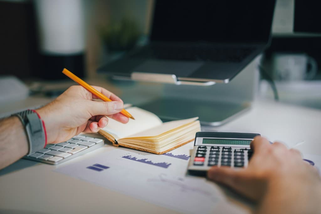 Calculatrice, carnet et documents comptables sur un bureau